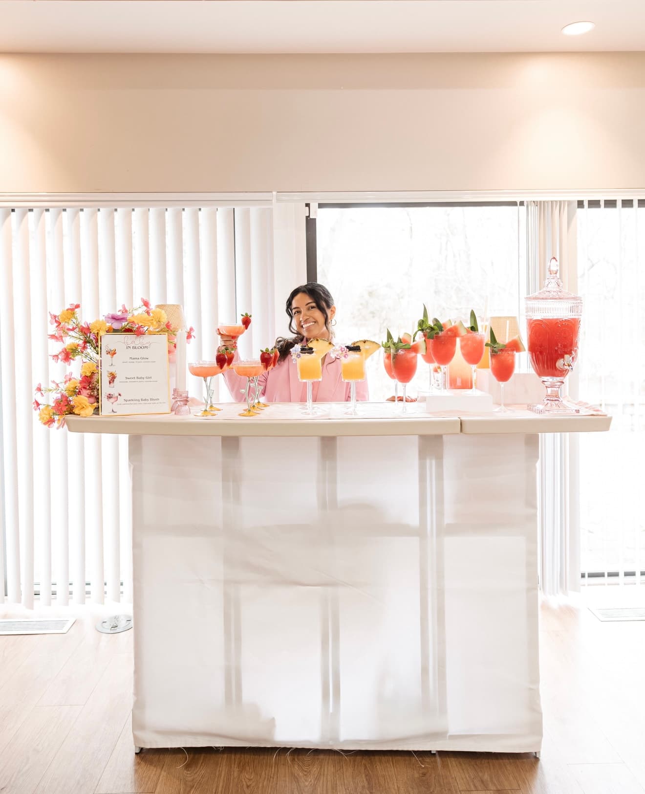 Ana garnishing a signature cocktail behind a styled bar